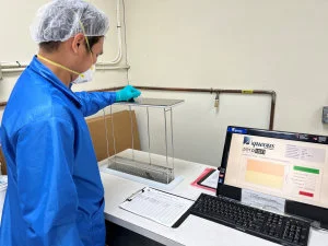 An employee places circuit board in an ionic cleaning machine